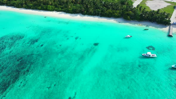 Wide angle flying island view of a summer white paradise sand beach and blue sea background in vibrant