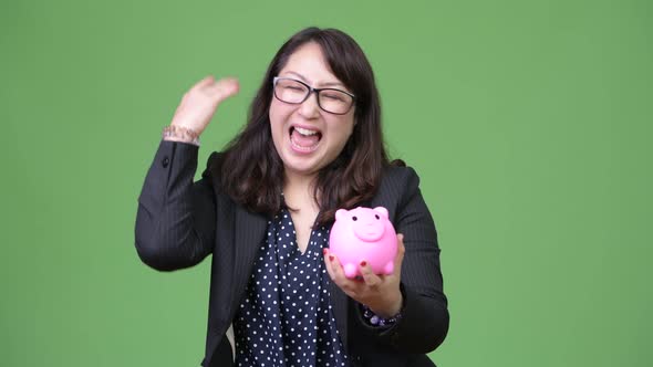 Mature Beautiful Asian Businesswoman Holding Piggy Bank