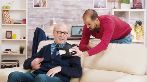 Nephew Showing His Grandfather How To Use VR Headset