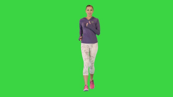 Female Runner in Sporty Outfit Jogging on a Green Screen Chroma Key