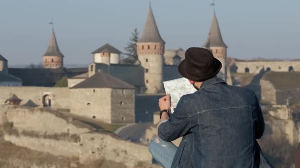 Young Traveler Man With Map Outdoors, Ancient Castle Background