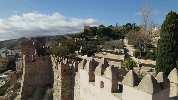 Aerial Dolly Left Over Walled Fortification Of Alcazaba of Almería With Gardens In Background