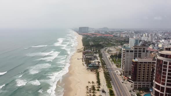 Aerial View of a Beautiful and Tranquil City with Big Buildings and Long White Sand Beach