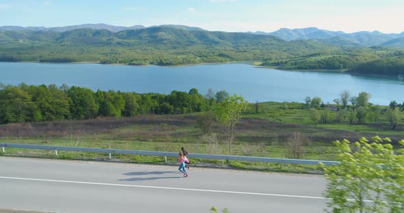 Women Jogging Together Near Lake, Practicing for Healthy Lifestyle