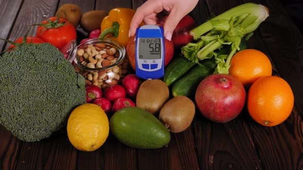 Lots of Vegetables and Fruits and a Blood Sugar Meter on a Wooden Background