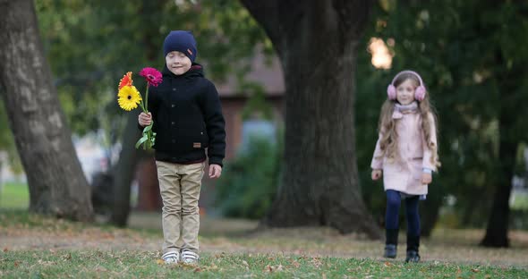 Little Girl Approached to the Little Boy in the Park