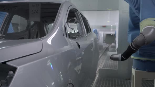 Robotic Arms Spray Painting a Vehicle Body at a Car Manufacturing Factory