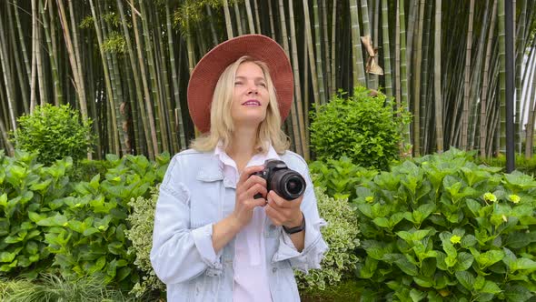 Photographer Takes a Pictures on a Camera in the Garden