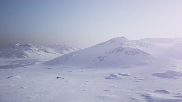 Aerial Landscape of Snowy Mountains and Icy Shores in Antarctica alt