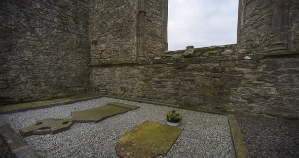 Motion time lapse of historical abbey and graveyard in rural Ireland during a cloudy day.