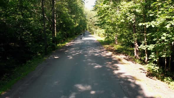 Two Adult Men Motorcyclists in Helmet Riding a Motorbike in the Forest