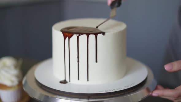 Young lovely woman pastry chef preparing birthday cake decorating with chocolate