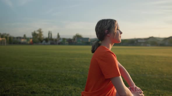 Young Beautiful Girl in Sweatpants and an Orange Tshirt Goes in for Sports