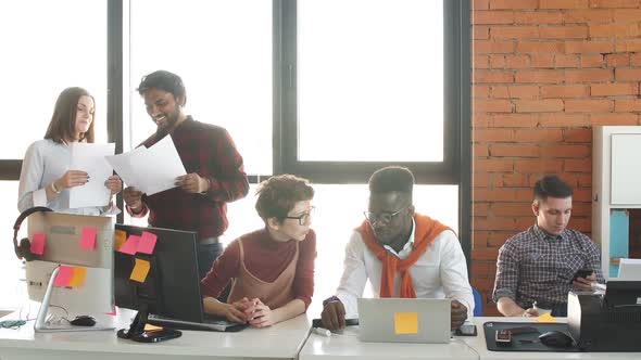 Young IT Specialist Are Discussing Data in the Office with Glass Walls.