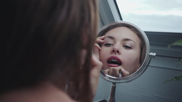 Young Woman Applying Lip Liner