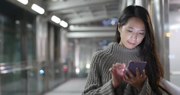Business woman using mobile phone in the city at night