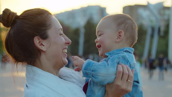 Happy Smiling Mother is Keeping in Arms Her Toddler Baby and Having Fun They are Laughing