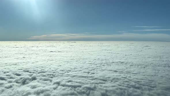 PILOT VIEW - From a jet plane cockpit, a dense flat blanket of cloud cover is seen below