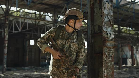 Armed Man in US Military Uniform Standing on Old Factory