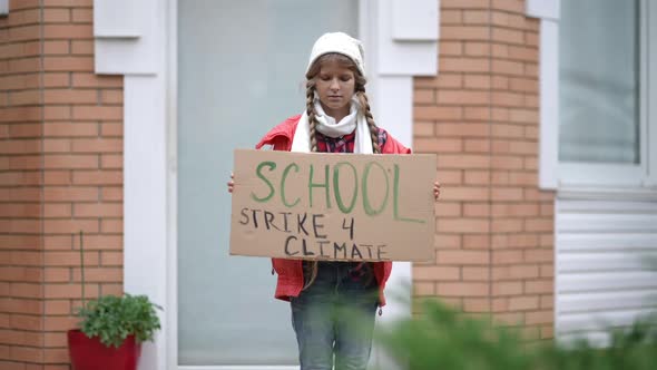 Confident Teenage Girl with School Strike for Climate Banner Standing Outdoors on Porch Looking at