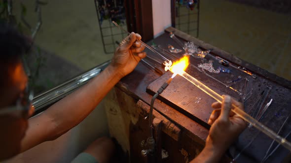 Senior man forming melted glass