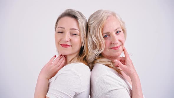 Two Blonde European Women Standing Back to Back Medium Closeup White Background Studio Shot Feminine