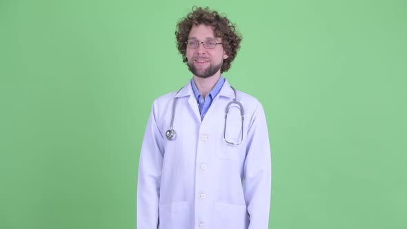 Happy Young Bearded Man Doctor Smiling and Thinking