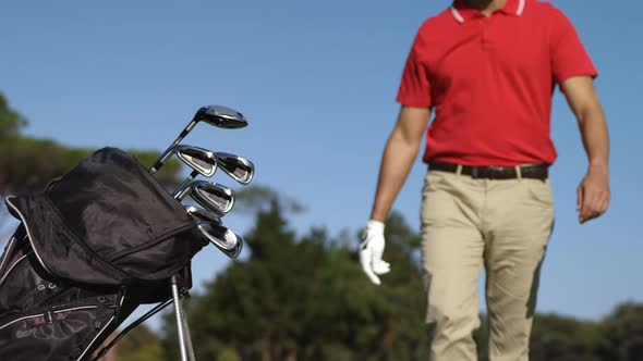 Male golfer removing golf club from golf bag