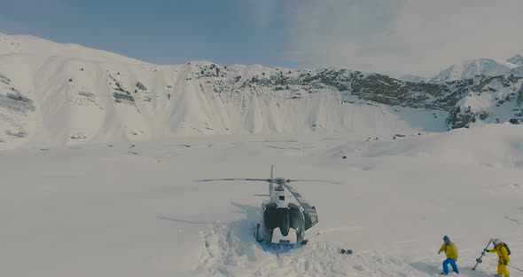 Aerial view The skiers go to the helicopter in the snowy mountains