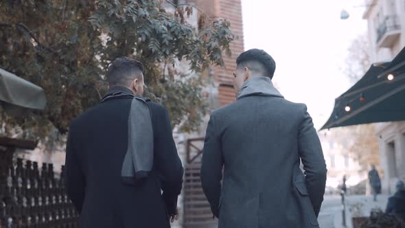 Serious businessmen walking in suits in the city. Slow motion