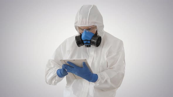 Male Doctor in Protective Suit Using Digital Tablet on Gradient Background.