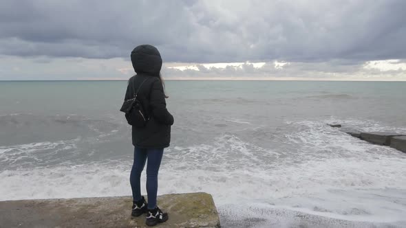 Female Traveler on Coast By the Sea Looking and Taking Pictures