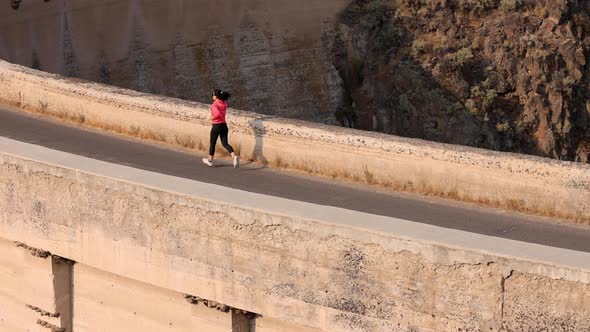 Asian woman jogging across the Salmon Falls Dam in Idaho