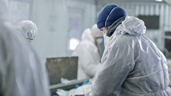 Workers in Protective Coveralls Sorting Plastic Waste