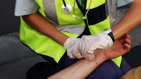 Emergency medical technician taking the pulse of his wounded person