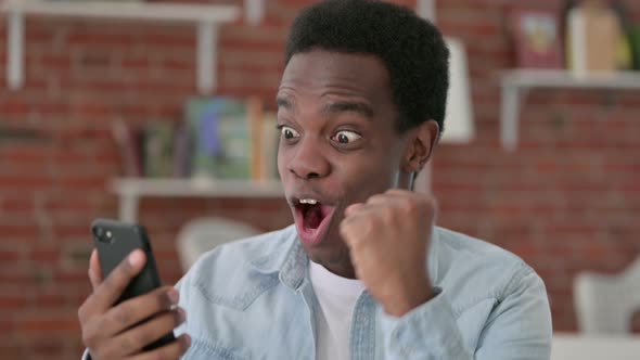 African Male Celebrating on Smartphone