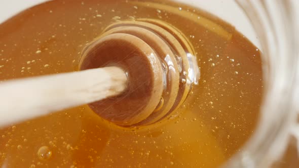 Spiral kitchen utensil in glass honey jar 4K 2160p 30fps UltraHD footage - Close-up of sweet food su