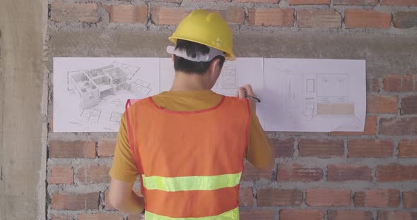 Male Building Designers Wearing Helmets And Drawings Diagram Of Future Buildings