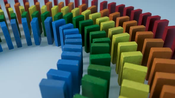 Line up of Dominoes in Rainbow Falling Colors with LGBT Colors of a Hand