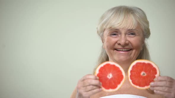 Optimistic Aging Lady Closing Eyes With Grapefruit Slices, Cosmetic Procedures