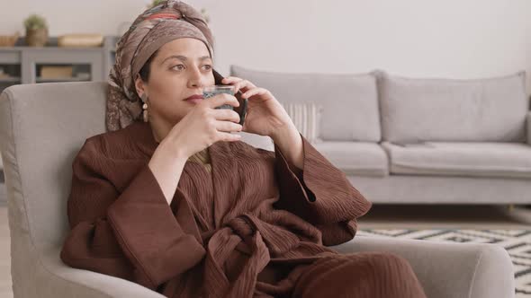 Muslim Woman Chatting on Phone at Home