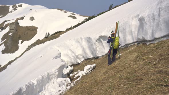 Young Skier Shooting Video of Avalanche Gap in Snowy Alpine Mountains in Sunny Winter Season