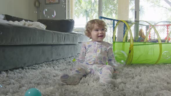 Slow Motion of Baby Girl Playing with Bubbles at Home