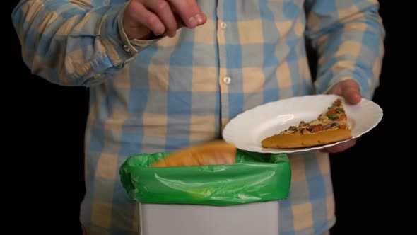 Man Scraping with a Plate a Pizza Into Garbage Bin