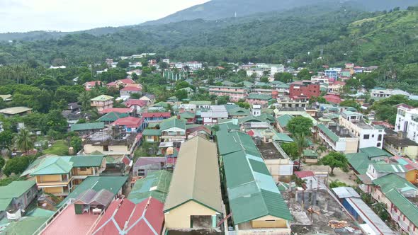 Aerial drone view from coastline towards the houses and buildings of Puerto Galera, Philippines