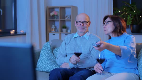 Happy Senior Couple Drink Red Wine and Watch Tv