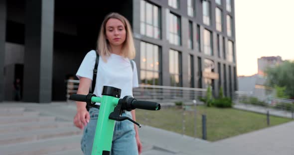 Woman rent scooter pay using smartphone on summer weekend close up.