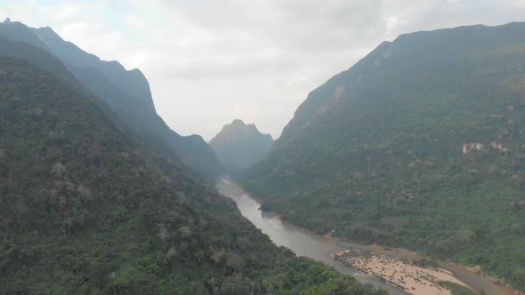 Aerial: drone flying over Nam Ou River in Laos, morning fog mist and clouds, Nong Khiaw Muang Ngoi d