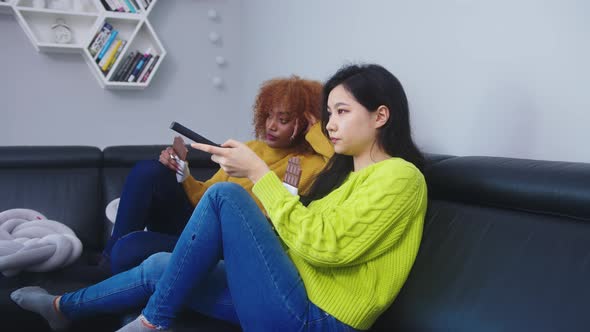 Two Women Lesbian Couple Watching Television and Eating Chocolates