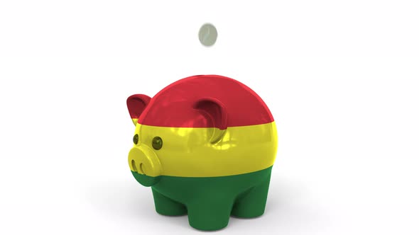 Coins Fall Into Piggy Bank Painted with Flag of Bolivia alt
